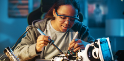 Teen female student holds tool for working on electric circuit